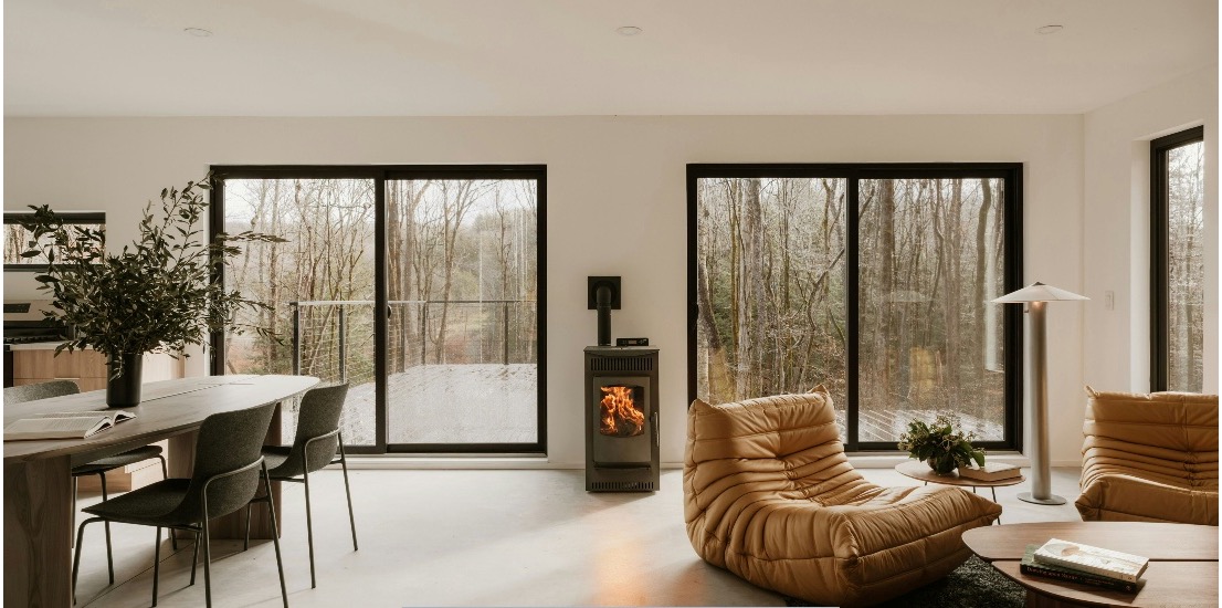 Contemporary living room showcasing black-framed replacement windows and a sliding patio door installation in Tempe, AZ.