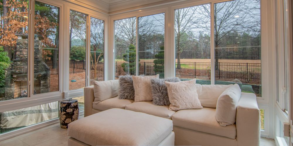 Bright sunroom featuring large replacement windows and doors in Chandler, AZ, overlooking a landscaped backyard.